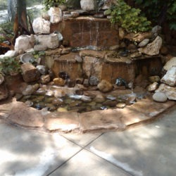 A fountain with rocks and water in the middle of it.