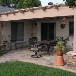 A patio with chairs and tables in the middle of it.